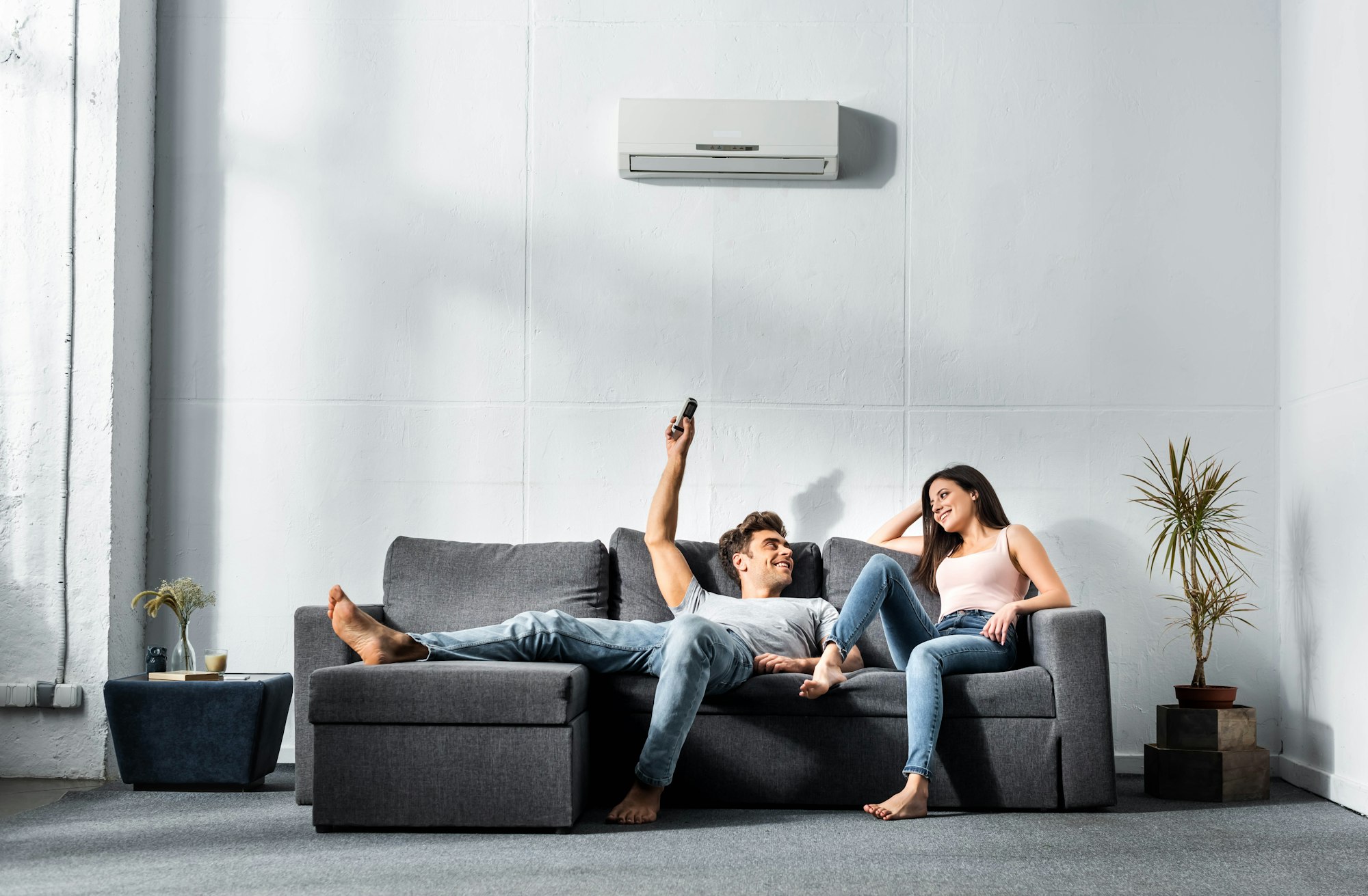 handsome-boyfriend-switching-on-air-conditioner-and-looking-at-smiling-girlfriend.jpg